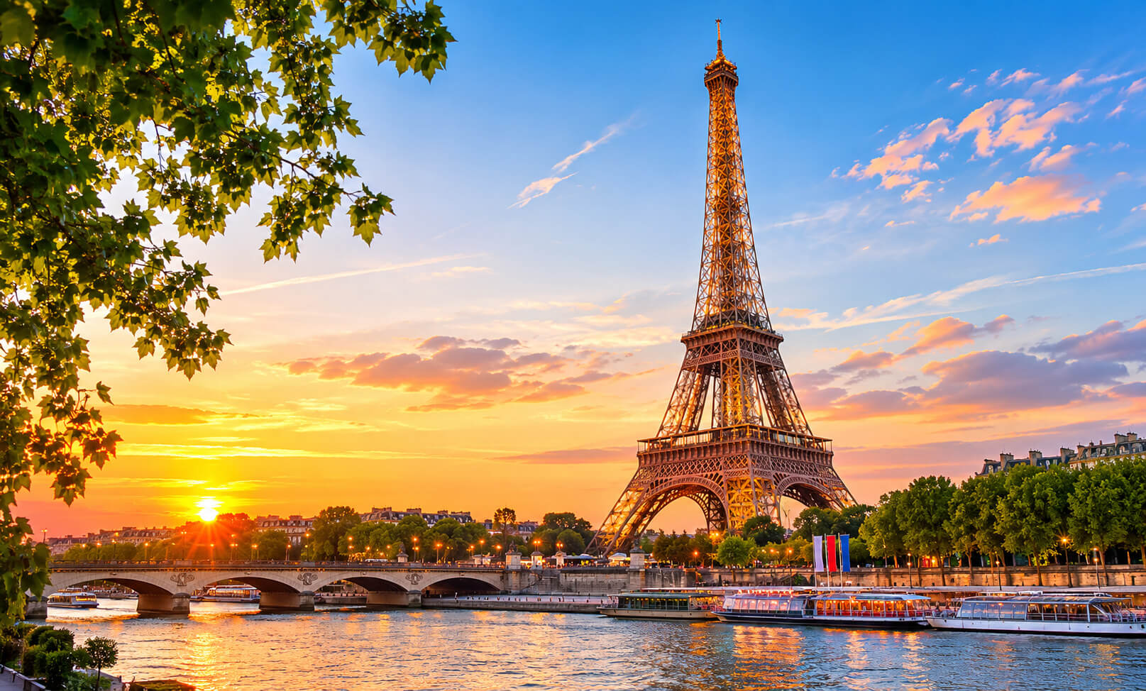 La Torre Eiffel y el río Sena con embarcaciones al atardecer en París.